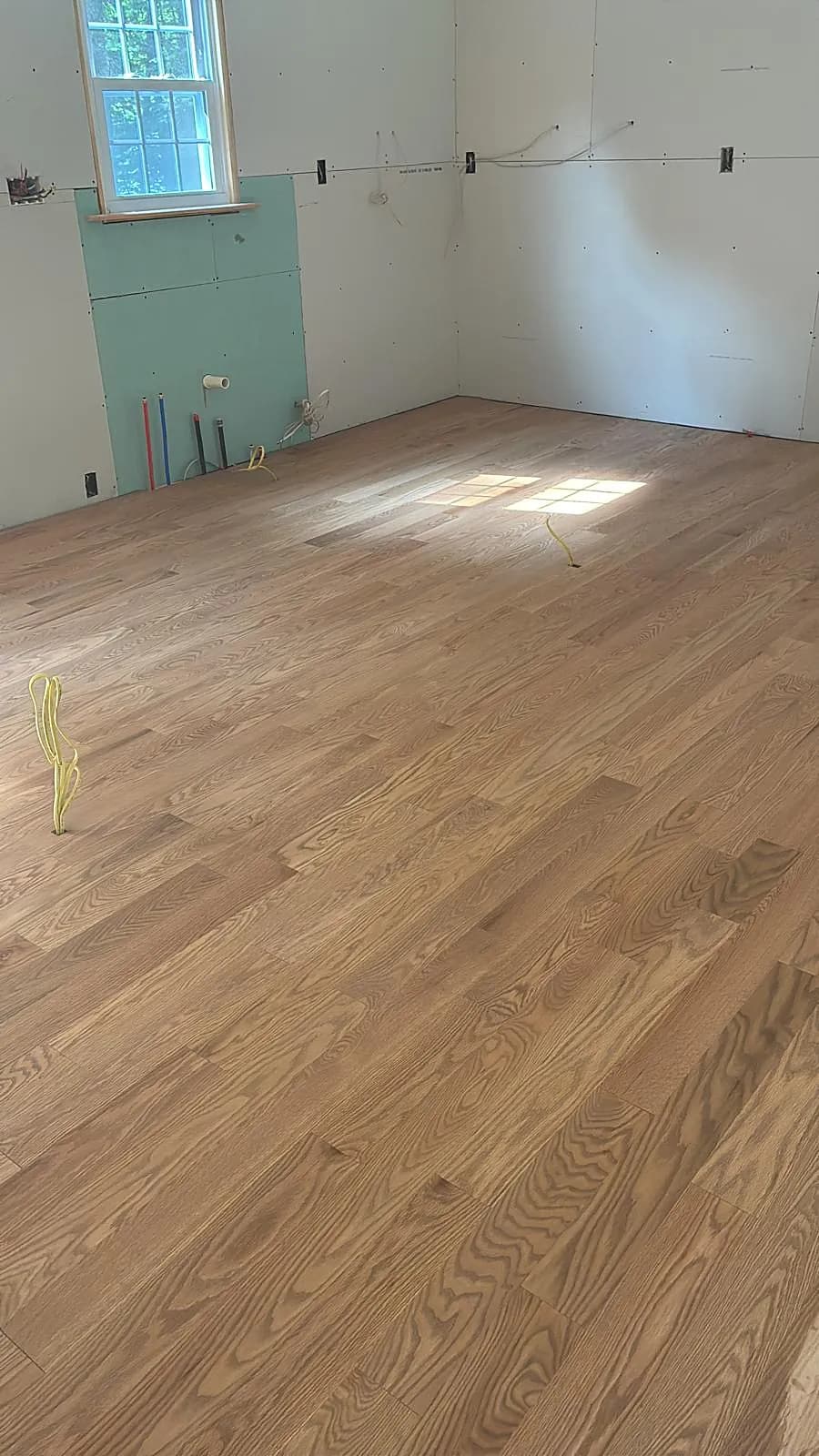 Newly installed red oak hardwood floor in a bright room