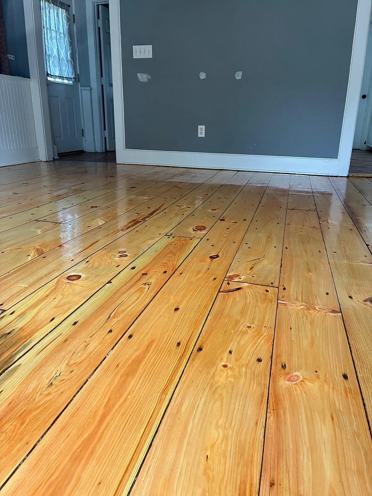 Wide-plank pine floor refinished to a natural glow in a New England home